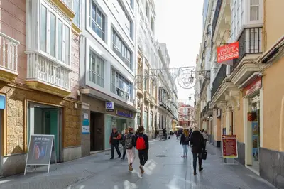 a group of people walking down a street with buildings at Atico del ROMANTICO Gaditano by Cadiz4Rentals in Cádiz
