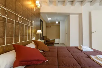 a bedroom with a large bed with red pillows at Atico del ROMANTICO Gaditano by Cadiz4Rentals in Cádiz