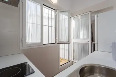 a kitchen with a sink and windows at Atico del ROMANTICO Gaditano by Cadiz4Rentals in Cádiz