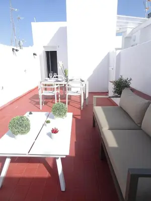 a living room with a couch and a table on a balcony at Atico Terraza Cadiz Centro Ascensor Playa de la Caleta in Cádiz