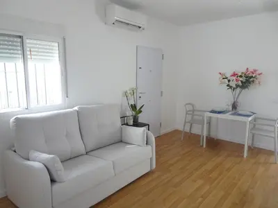 a white living room with a white couch and a table at Atico Terraza Cadiz Centro Ascensor Playa de la Caleta in Cádiz