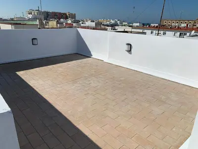 a balcony with a brick floor and white walls at Atico Terraza Cadiz Centro Ascensor Playa de la Caleta in Cádiz