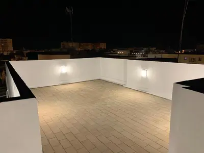 a white wall with two lights on a tiled floor at Atico Terraza Cadiz Centro Ascensor Playa de la Caleta in Cádiz