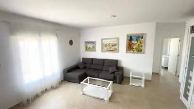 a living room with a couch and a table at Chalet en Conil, descansa y disfruta BBQ AIRE PISCINA PARKING in Conil de la Frontera
