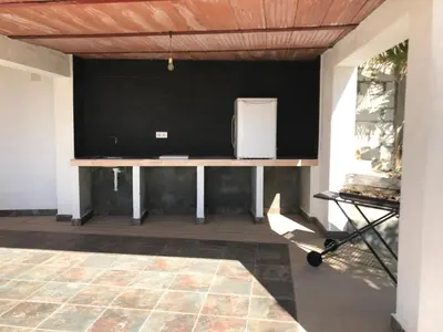 a living room with a table and a tv at Chalet en Conil, descansa y disfruta BBQ AIRE PISCINA PARKING in Conil de la Frontera