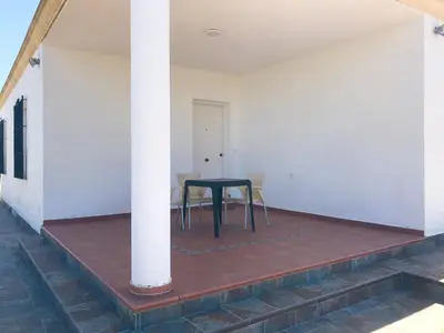 a black table in a room with a pillar at Chalet en Conil, descansa y disfruta BBQ AIRE PISCINA PARKING in Conil de la Frontera