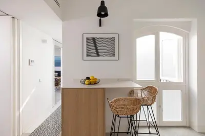 a kitchen with a counter and two stools at Candelaria10 in Cádiz