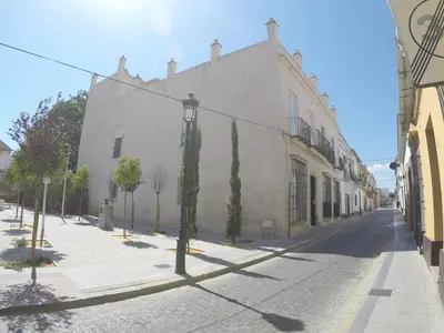 an empty street with a large white building at El Rinconcito - apartamento palacete rehabilitado in El Puerto de Santa María