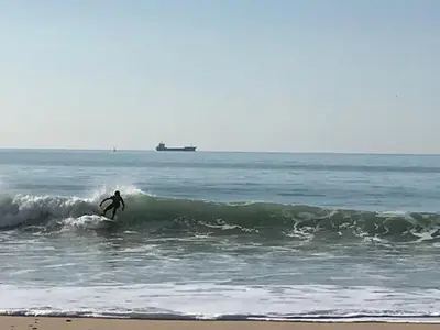 a person riding a wave on a surfboard in the ocean at El Rinconcito - apartamento palacete rehabilitado in El Puerto de Santa María