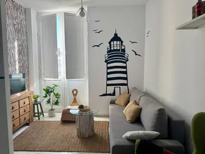a living room with a couch and a lighthouse stencil on the wall at El Rinconcito - apartamento palacete rehabilitado in El Puerto de Santa María