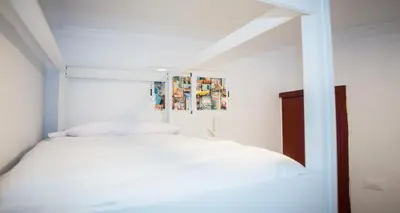 a room with three white bunk beds in it at Vivian's Guest House Auto Check-in in Jerez de la Frontera