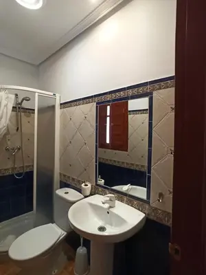 a bedroom with a bed with blue sheets and a window at Vivian's Guest House Auto Check-in in Jerez de la Frontera