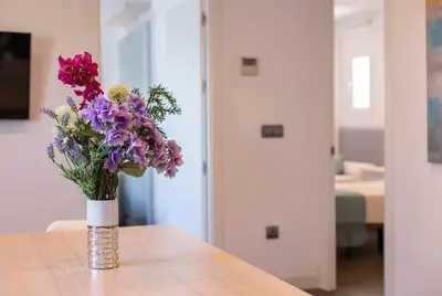 a vase filled with purple flowers sitting on a table at San Jose 2 baños in Cádiz