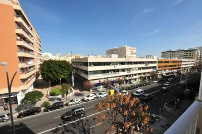 a city street with cars parked in a parking lot at San Jose 2 baños in Cádiz