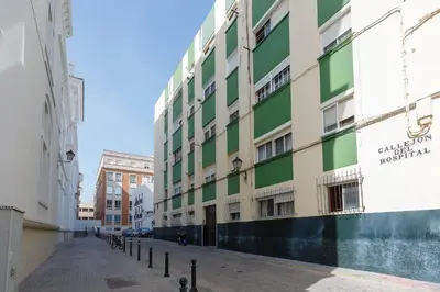 a green and white building on a city street at El TESORO de la Caleta by Cadiz4Rentals in Cádiz