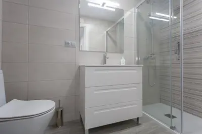 a white bathroom with a toilet and a shower at El TESORO de la Caleta by Cadiz4Rentals in Cádiz