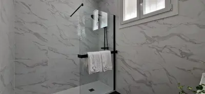 a bathroom with a shower with a towel on a glass door at Apartamentos Arenal in Jerez de la Frontera