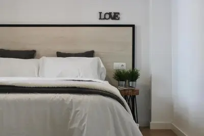 a bedroom with a white bed with a large headboard at GATU PREMIUM Villa Aramburu, 
