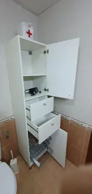 a bathroom with a white cabinet with a red cross on it at Duplex Calle Padre Lerchundi con Parking y wifi in Chipiona