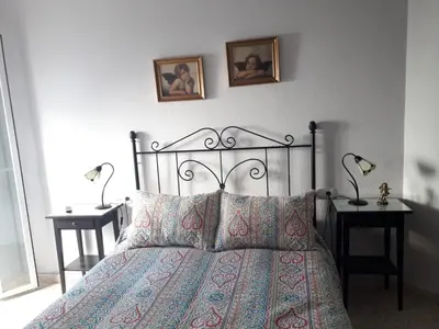 a bedroom with a bed with two end tables and two lamps at Duplex Calle Padre Lerchundi con Parking y wifi in Chipiona