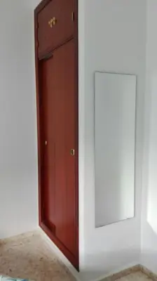 a wooden door and a mirror in a room at Duplex Calle Padre Lerchundi con Parking y wifi in Chipiona