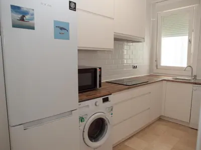 a kitchen with a washing machine and a microwave at La Casa del Arte in Cádiz