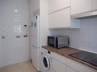 a kitchen with a microwave and a washer and dryer at La Casa del Arte in Cádiz