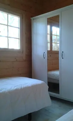 a bedroom with a bed and a mirror at Casita de madera junto al mar in El Puerto de Santa María