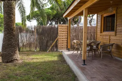 a patio with a table and chairs on a house at Casita de madera junto al mar in El Puerto de Santa María