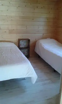 two beds in a room with wooden walls at Casita de madera junto al mar in El Puerto de Santa María