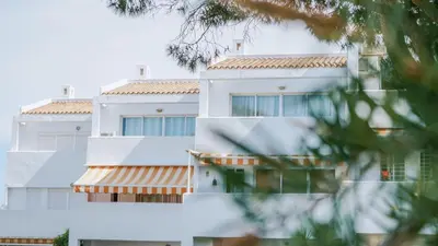 a white building with a red roof at Retama Golf Nº 55 by Fontanilla Del Mar Holidays Rentals in Chiclana de la Frontera