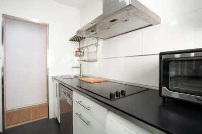 a kitchen with white cabinets and a black counter top at BARQUILLAS de la Caleta Home by Cadiz4Rentals in Cádiz