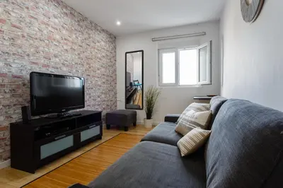 a living room with a couch and a flat screen tv at BARQUILLAS de la Caleta Home by Cadiz4Rentals in Cádiz