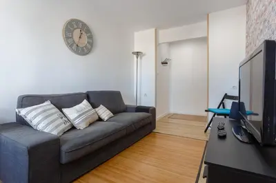 a living room with a couch and a clock on the wall at BARQUILLAS de la Caleta Home by Cadiz4Rentals in Cádiz