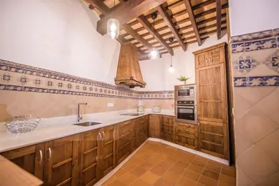 a kitchen with wooden cabinets and a sink and a stove at Casa Boutique Sanlucar in Sanlúcar de Barrameda