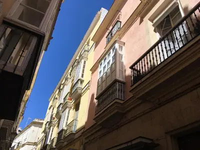 a building with a clock on the side of it at Casa Conchita in Cádiz