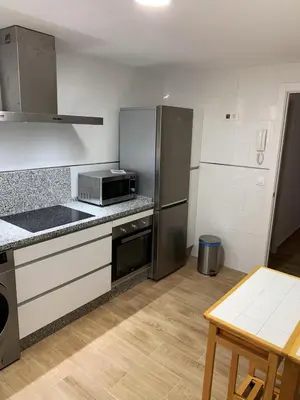 a kitchen with stainless steel appliances and a table at Casa Conchita in Cádiz