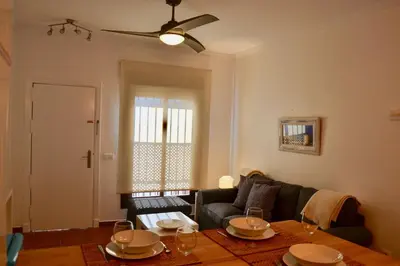 a living room with a couch and a table at Chipiona Acogedor in Chipiona