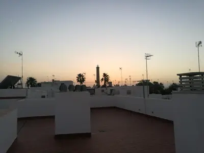 a view of a building with a clock tower in the background at Chipiona Acogedor in Chipiona