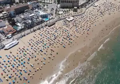 an overhead view of a crowded beach with umbrellas at Chipiona Acogedor in Chipiona