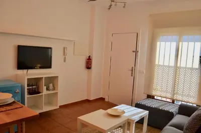 a living room with a couch and a tv at Chipiona Acogedor in Chipiona
