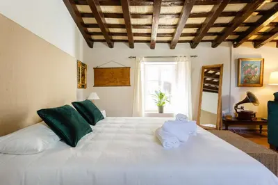 a bedroom with a large white bed with towels on it at Loft Catedral Jerez in Jerez de la Frontera