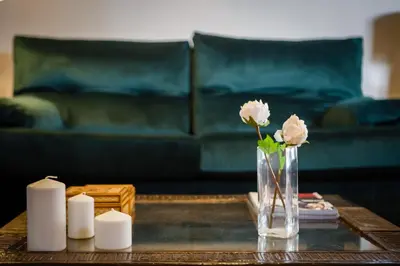 a vase of flowers on a coffee table with candles at Loft Catedral Jerez in Jerez de la Frontera