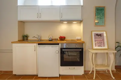 a kitchen with white cabinets and a sink and a stove at Loft Catedral Jerez in Jerez de la Frontera