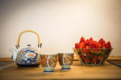 a table with a tea pot and a bowl of strawberries at Loft Catedral Jerez in Jerez de la Frontera