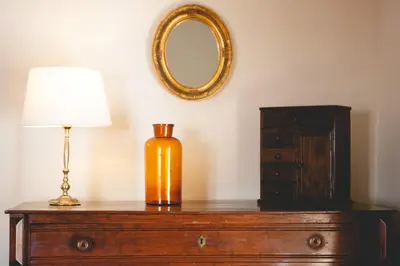a lamp on top of a dresser with a mirror at Suite Catedral Jerez in Jerez de la Frontera