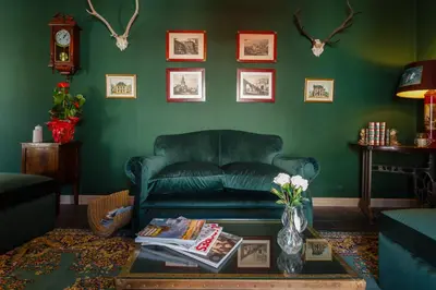 a living room with a green couch and a table at Suite Catedral Jerez in Jerez de la Frontera