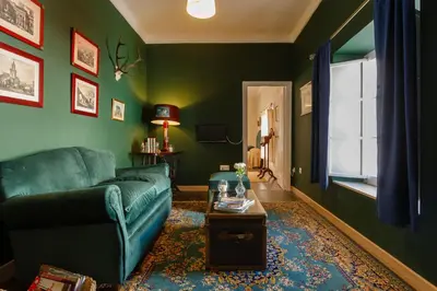 a green living room with a couch and a table at Suite Catedral Jerez in Jerez de la Frontera