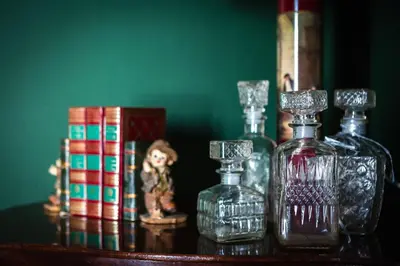 a group of glass bottles and books on a table at Suite Catedral Jerez in Jerez de la Frontera