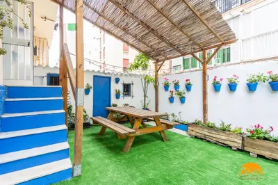 a patio with a wooden picnic table and potted plants at Garcia Rooms by Cadiz Time in Cádiz